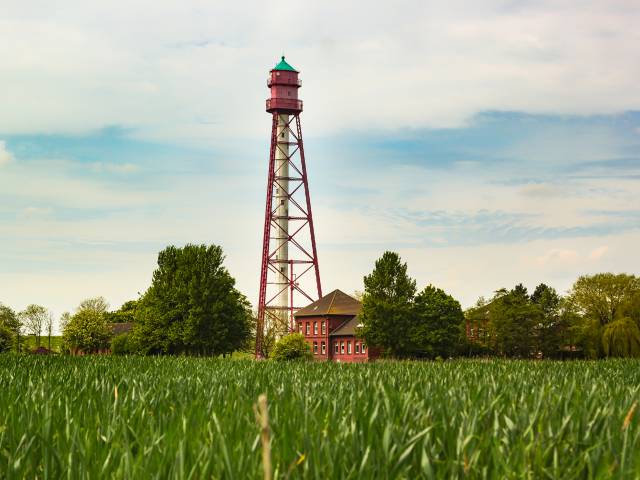 Ein Wasserturm und ein Haus am Feldrand