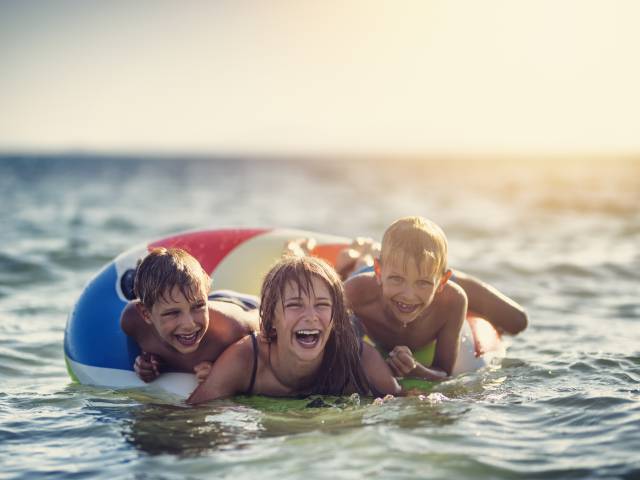 Drei Kinder in einem Schwimmring in der Nordsee