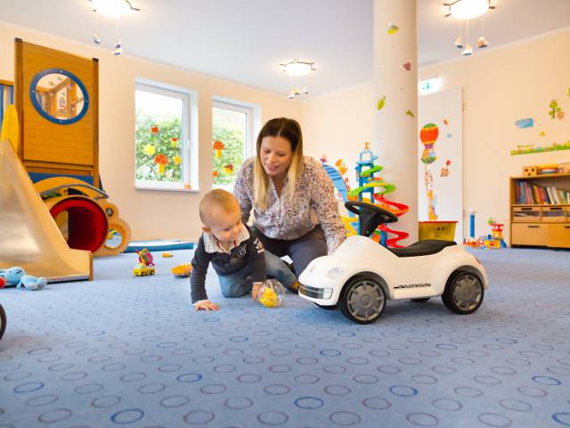 Mutter spielt mit ihre kleinen Sohn im Spielbereich des Hotel Deichkrone