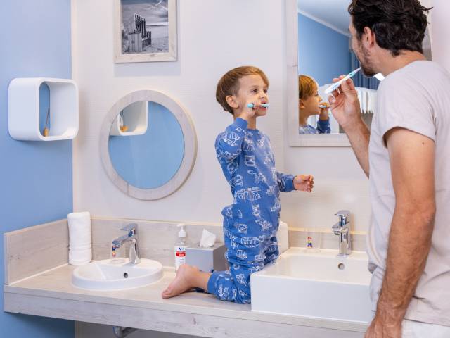 Papa und Sohn im Badezimmer beim Zähneputzen