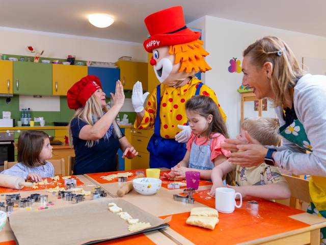 Maskottche Happy hilft beim Backen im Kidsclub