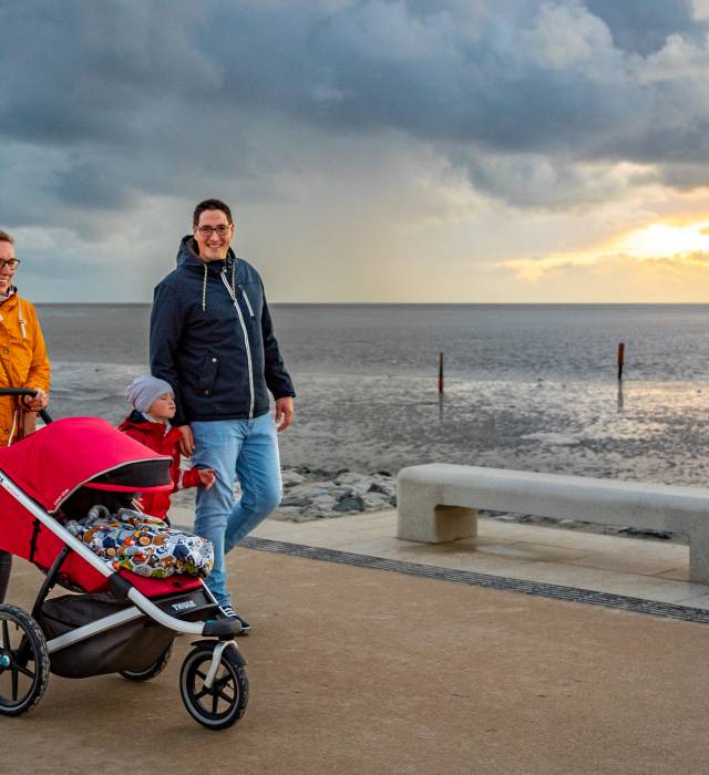 Familie Mit Kinderwagen machen einen Spaziergang entlang der Nordseeküste