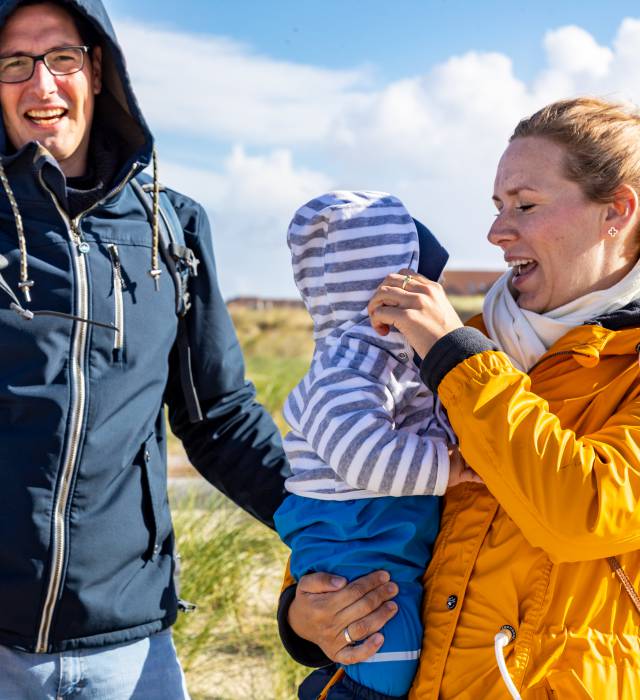 Mama, Papa und Kind machen sich bereit für den windigen Strand an der Nordsee
