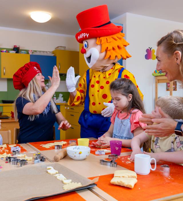 Maskottche Happy hilft beim Backen im Kidsclub