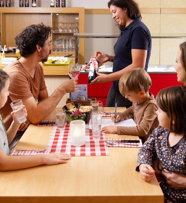 Familie im Restaurant und Papa bekommt eine Weinempfehlung