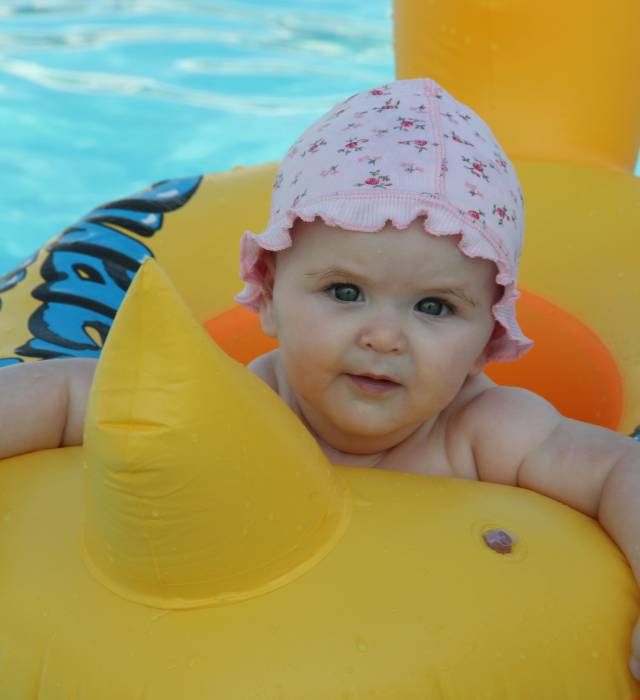 Baby sitzt im Schwimmring im Pool