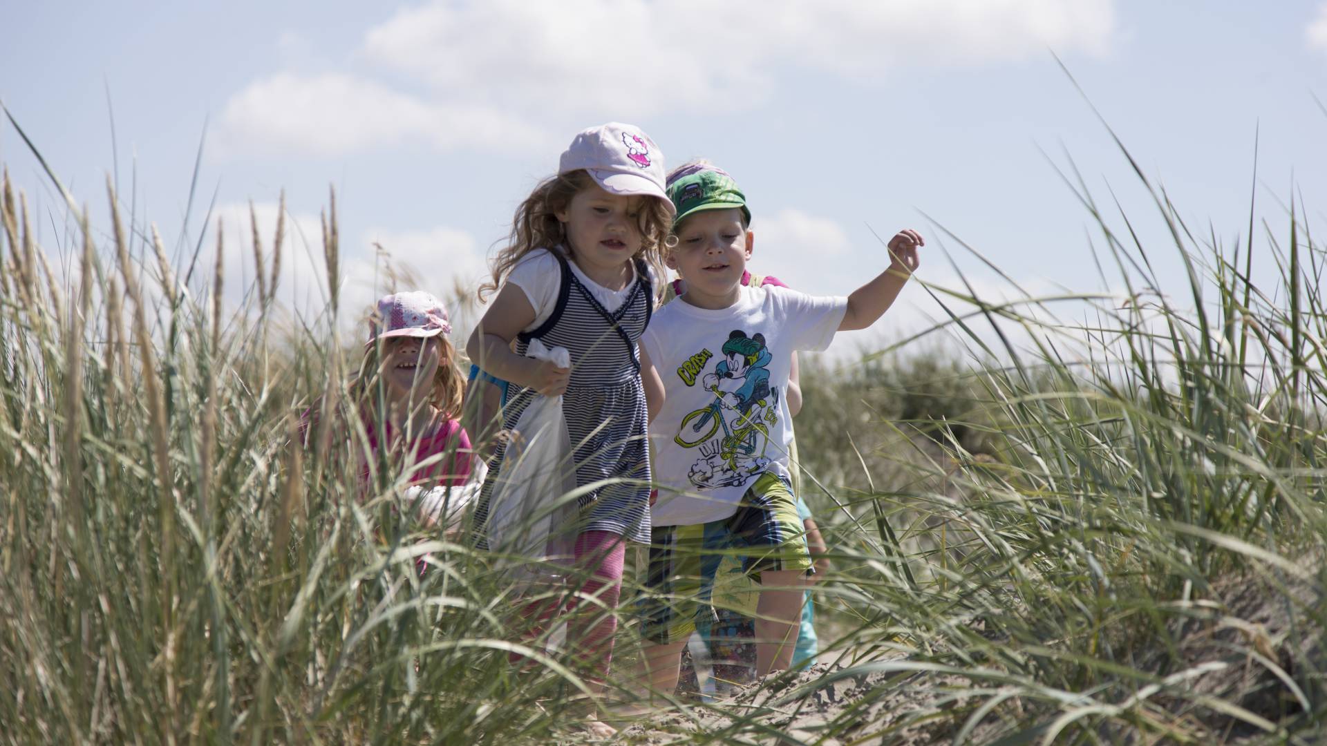 Kinder laufen durch die Dünen an der Nordsee