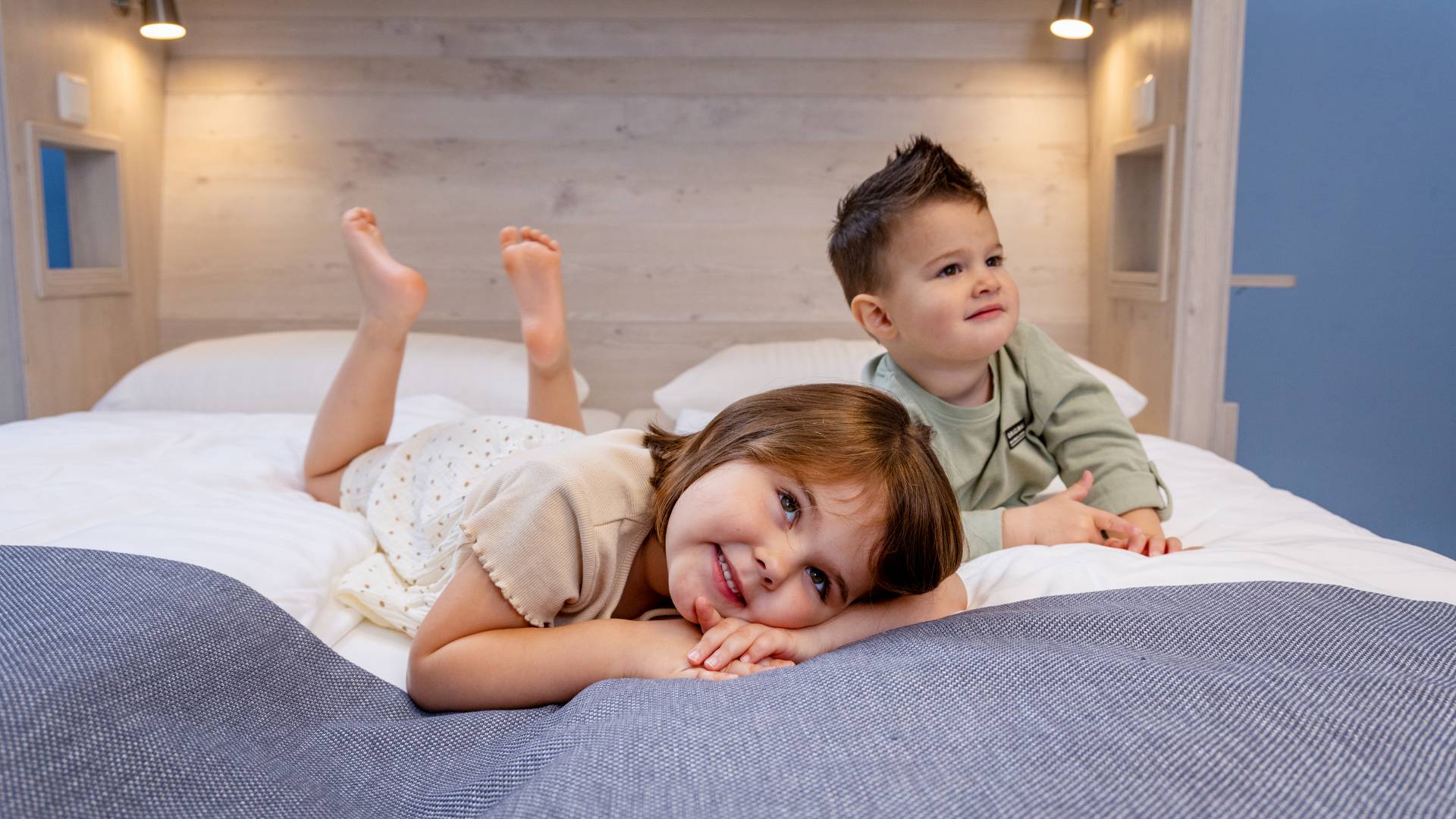 Zwei kleine Kinder liegen im Elternbett im Hotel Deichkrone