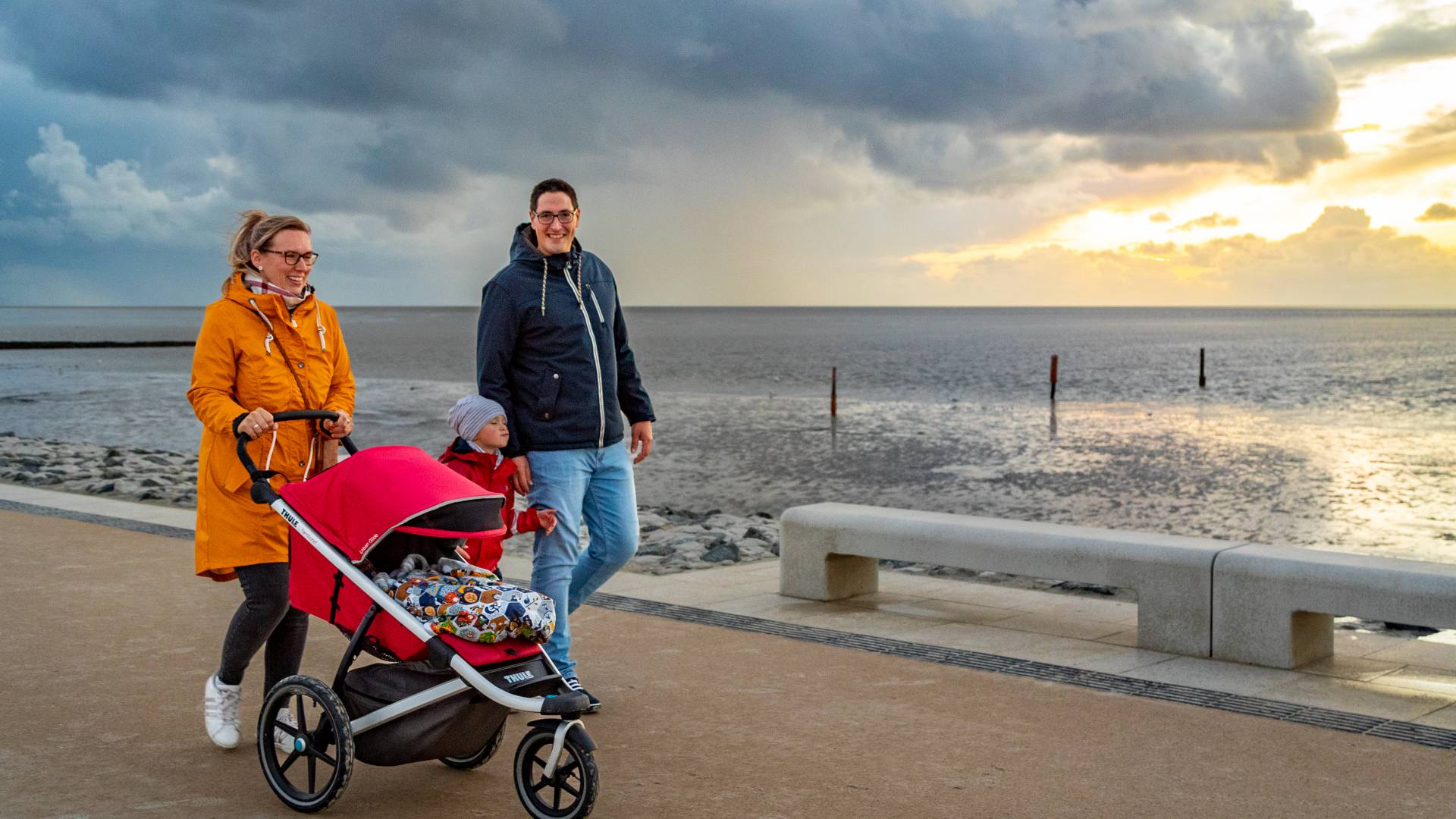 Familie Mit Kinderwagen machen einen Spaziergang entlang der Nordseeküste