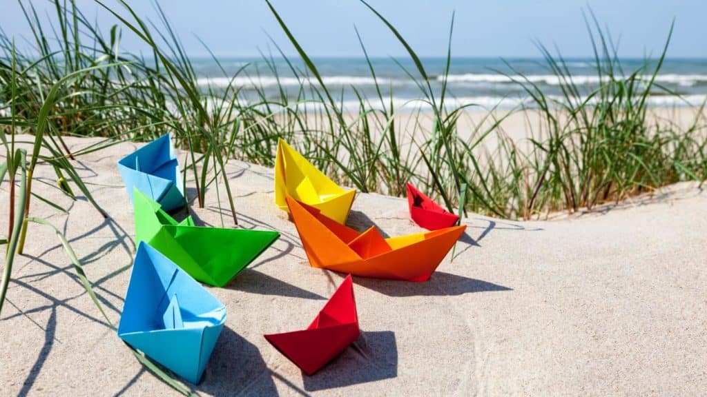 Strand und bunte Papierboote